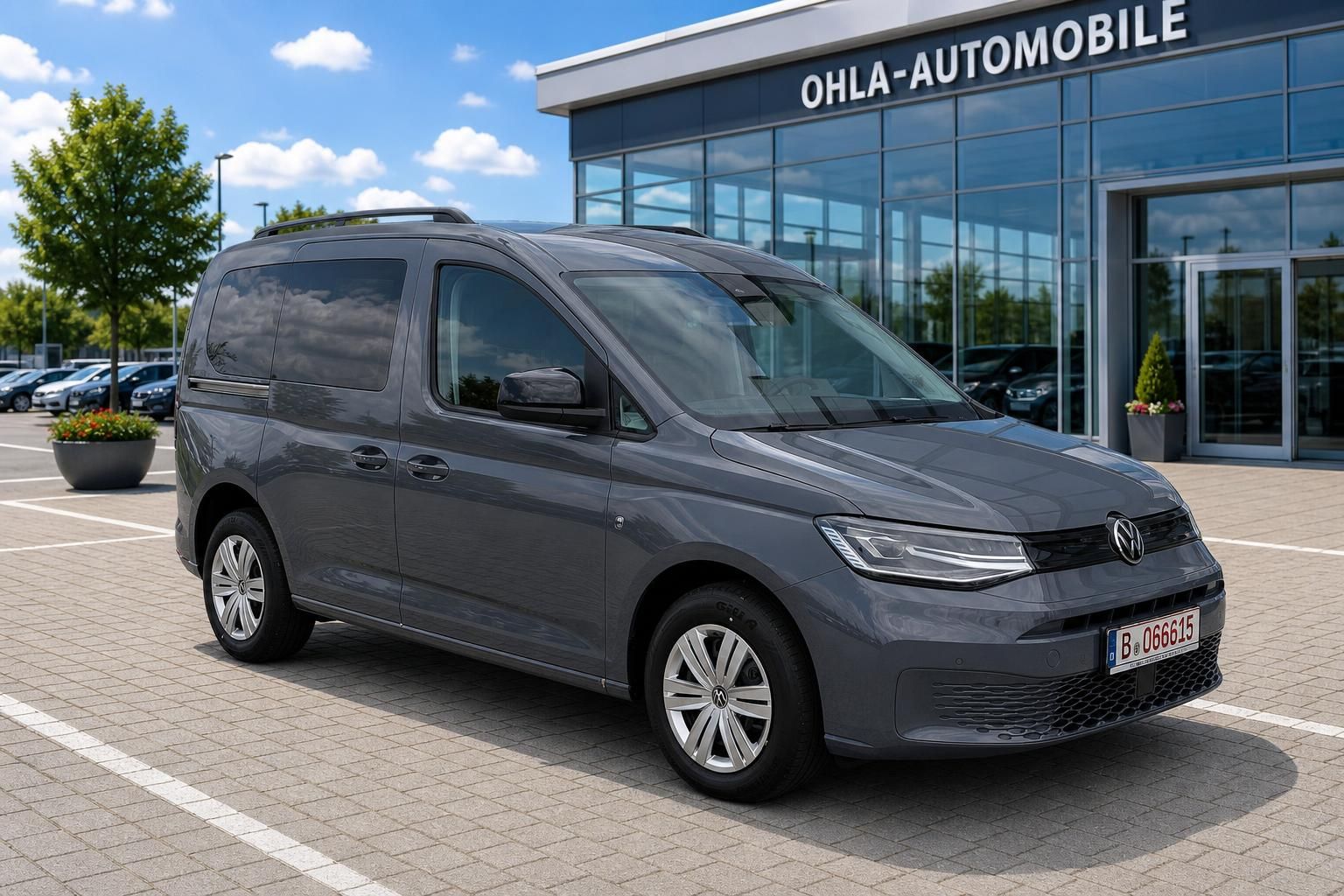 VW Caddy grau Frontansicht schraeg vor Autohaus geparkt