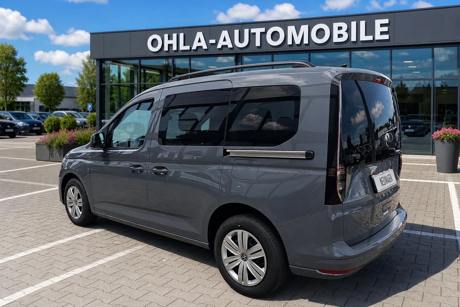 VW Caddy grau Heckansicht schraeg vor Autohaus Ohla-Automobile