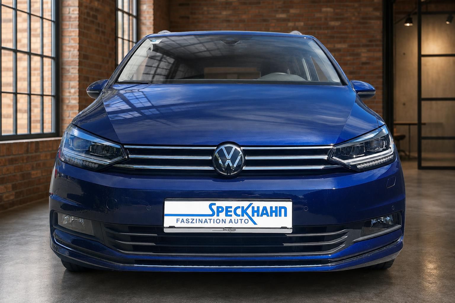 VW Touran blau Frontansicht mit Kennzeichenhalter Speckhahn im Showroom