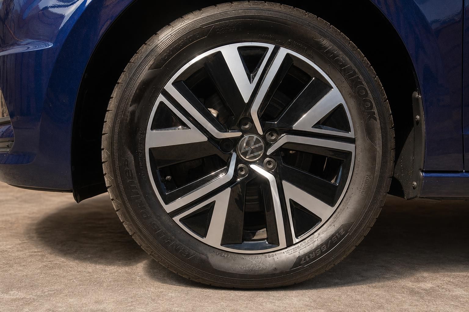 Detailansicht Leichtmetallfelge und Reifen des blauen VW Touran