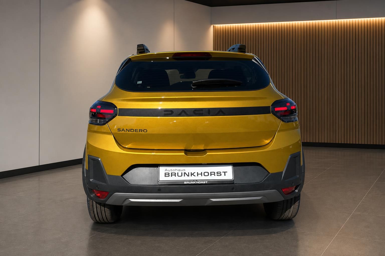 Dacia Sandero Stepway gelb Heckansicht mit Kennzeichen Autohaus Brunkhorst im Showroom