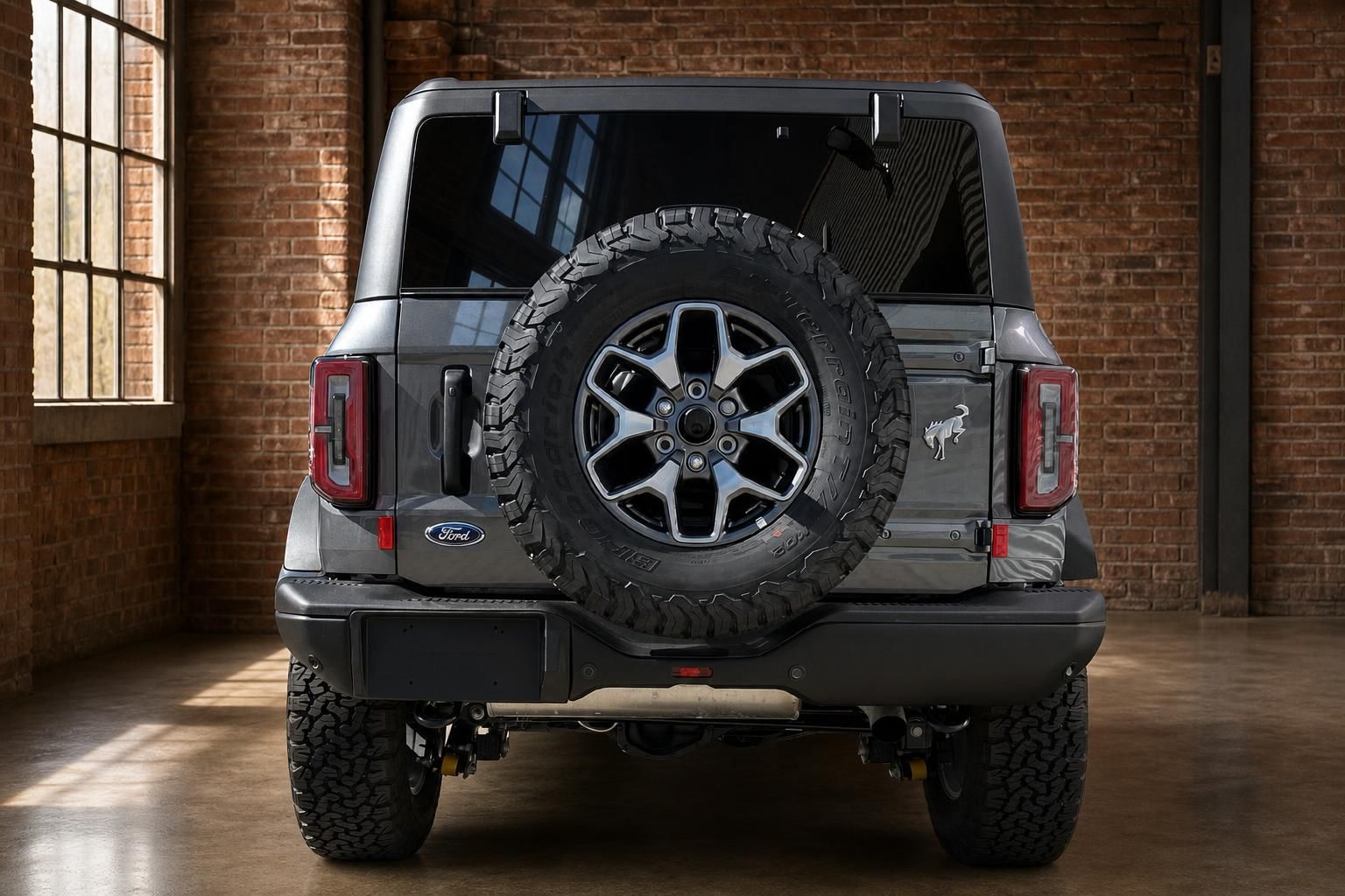 Ford Bronco grau SUV direkte Heckansicht mit Reserverad in Industriehalle