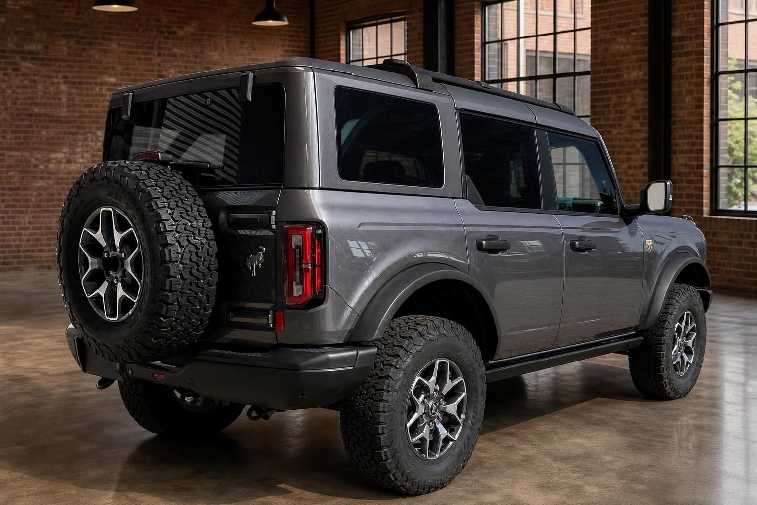 Ford Bronco grau SUV Heckansicht schräg mit Reserverad in Industriehalle
