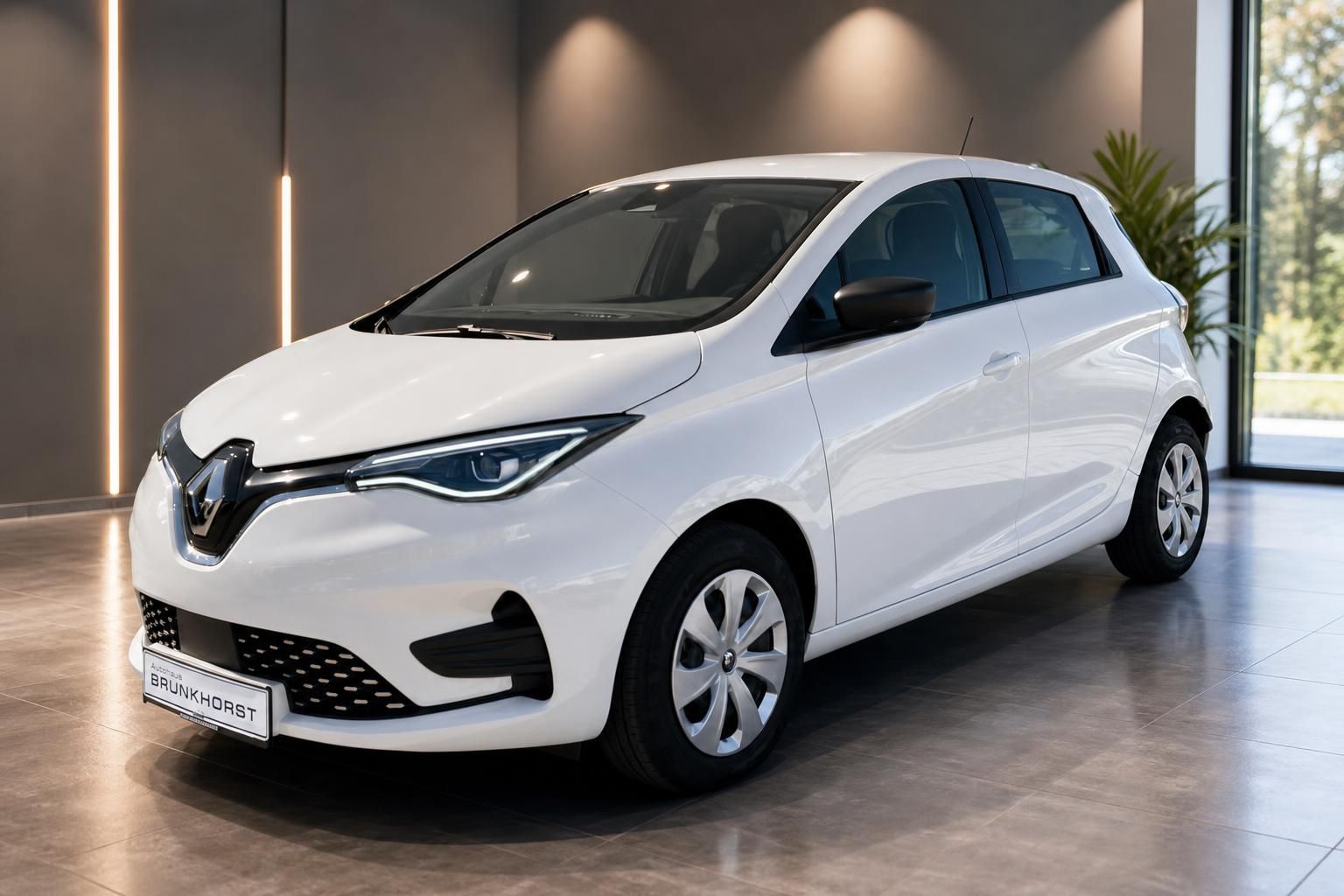 Weißer Renault ZOE Seitenansicht im Autohaus-Showroom mit Glasfront