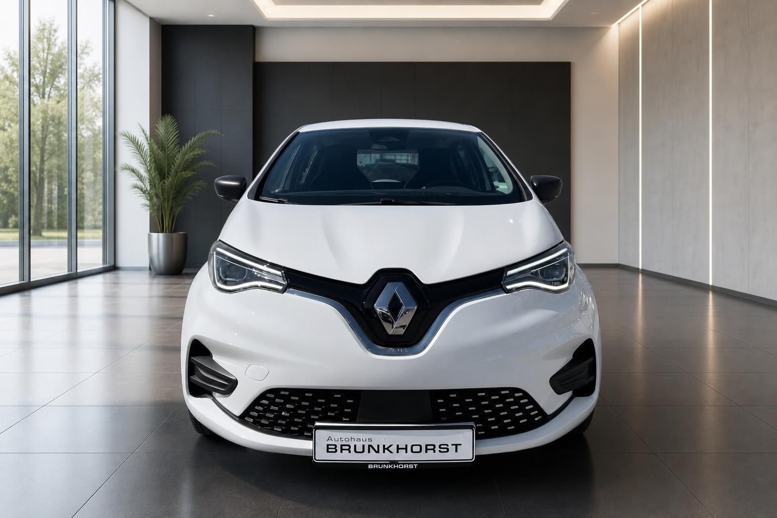 Weißer Renault ZOE Elektroauto Frontansicht im modernen Autohaus-Showroom