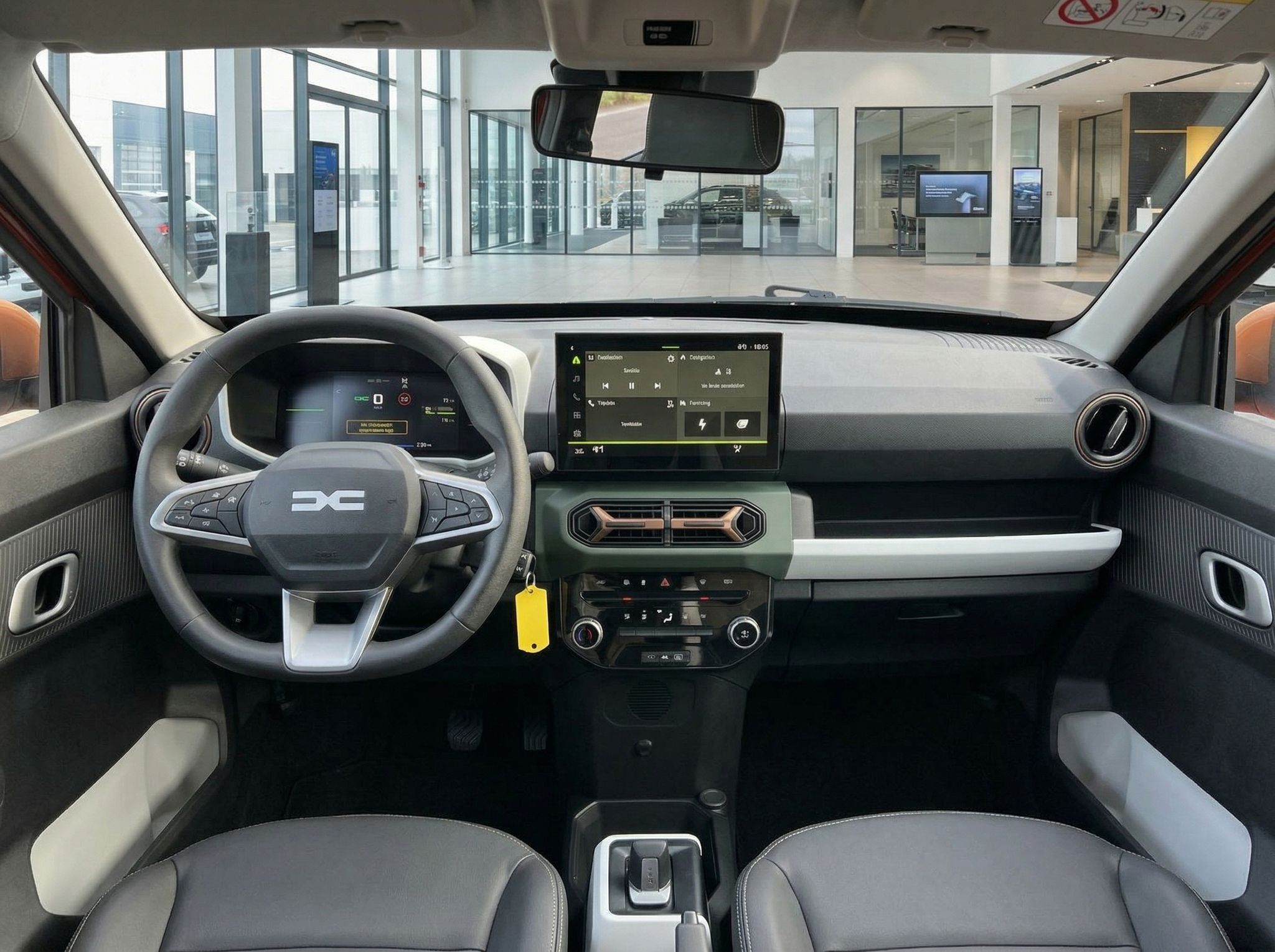 Modernes Fahrzeug-Cockpit mit digitalem Display, Lenkrad und Armaturenbrett in grau-schwarzer Ausstattung