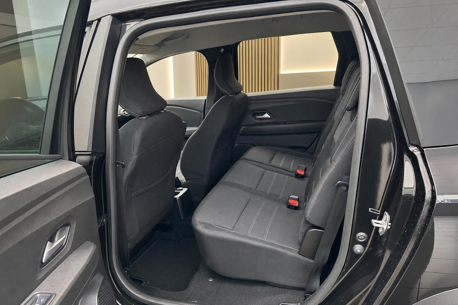 Dacia Fahrzeug Rücksitz Innenraum mit grauen Sitzen und offener Fahrzeugtür