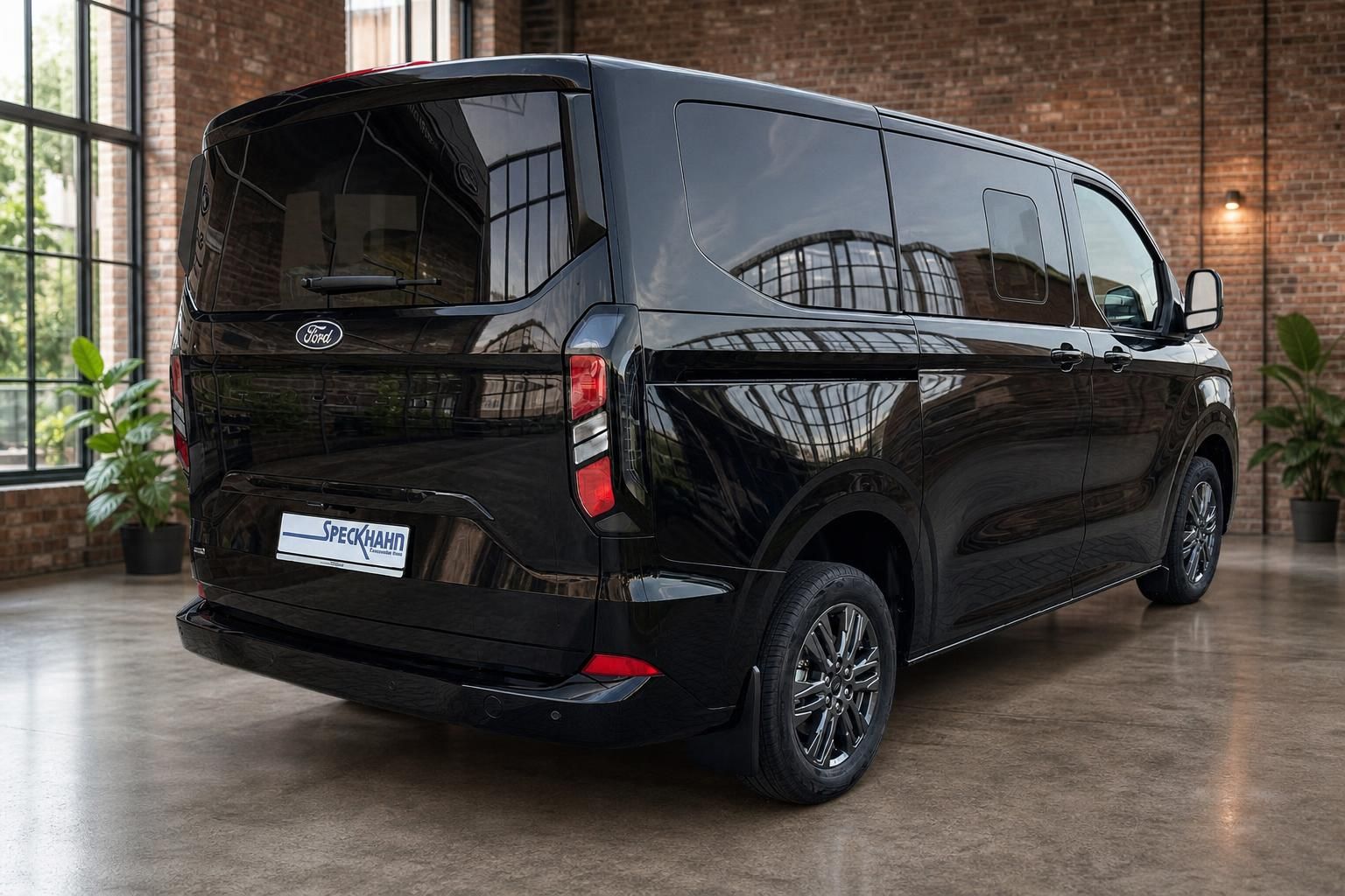 Ford Tourneo schwarz Heck seitlich mit gruenen Pflanzen im Loft
