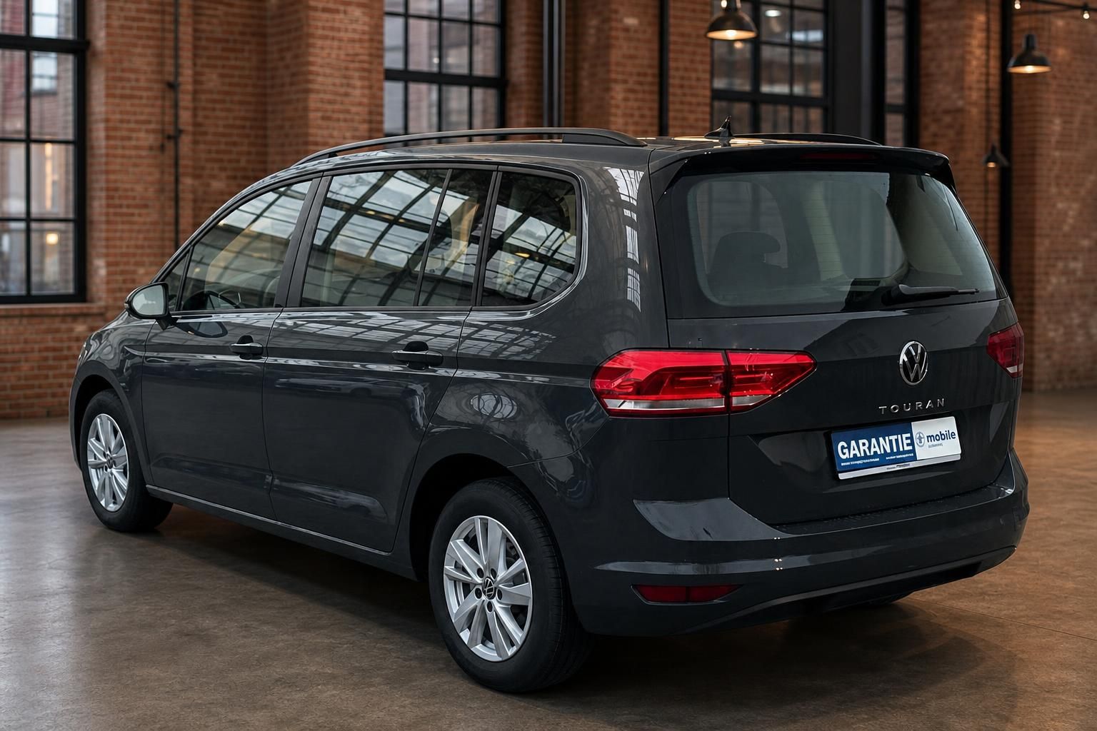 VW Touran schwarz Heckansicht seitlich in Loft-Halle