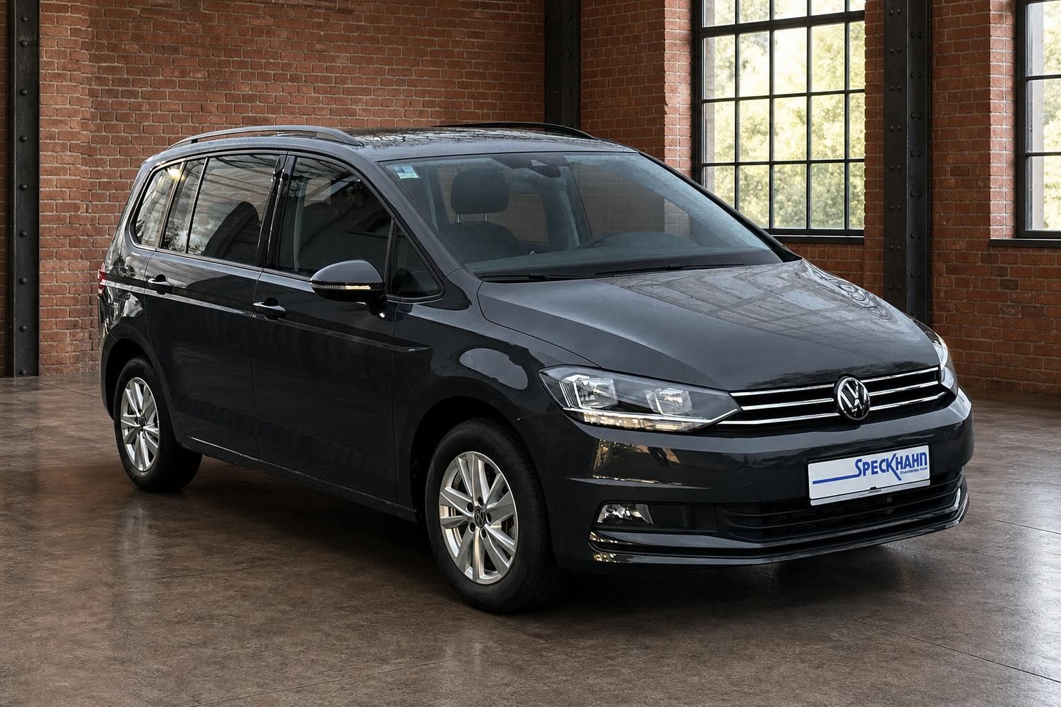 VW Touran schwarz Frontansicht seitlich vor Backsteinwand