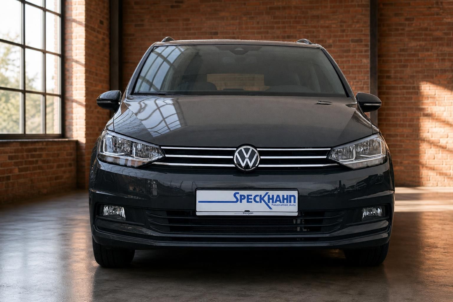 VW Touran Frontansicht grau in historischer Halle mit Backsteinwand
