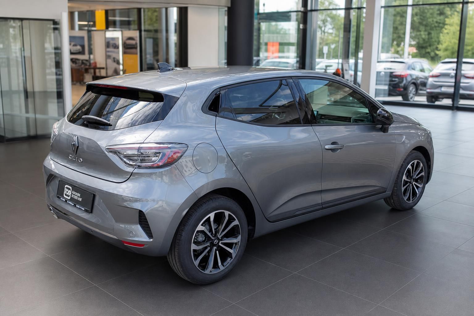 Renault Clio in Grau, Seiten- und Heckansicht im Autohaus