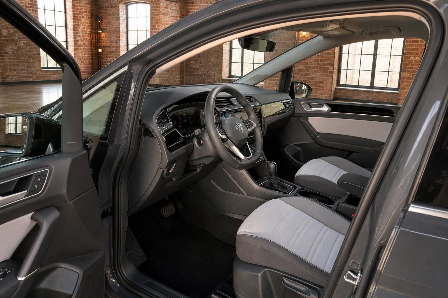 Innenraum VW Touran mit Cockpit, Lenkrad und Sitzen bei geöffneter Tür