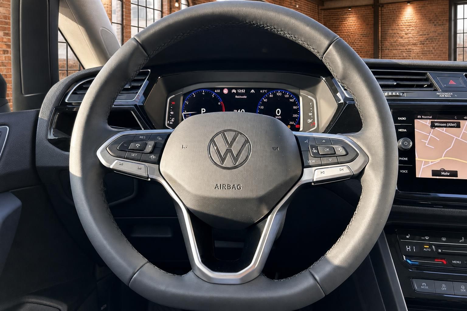 VW Lenkrad Nahaufnahme mit Multifunktionstasten und Navigationsdisplay
