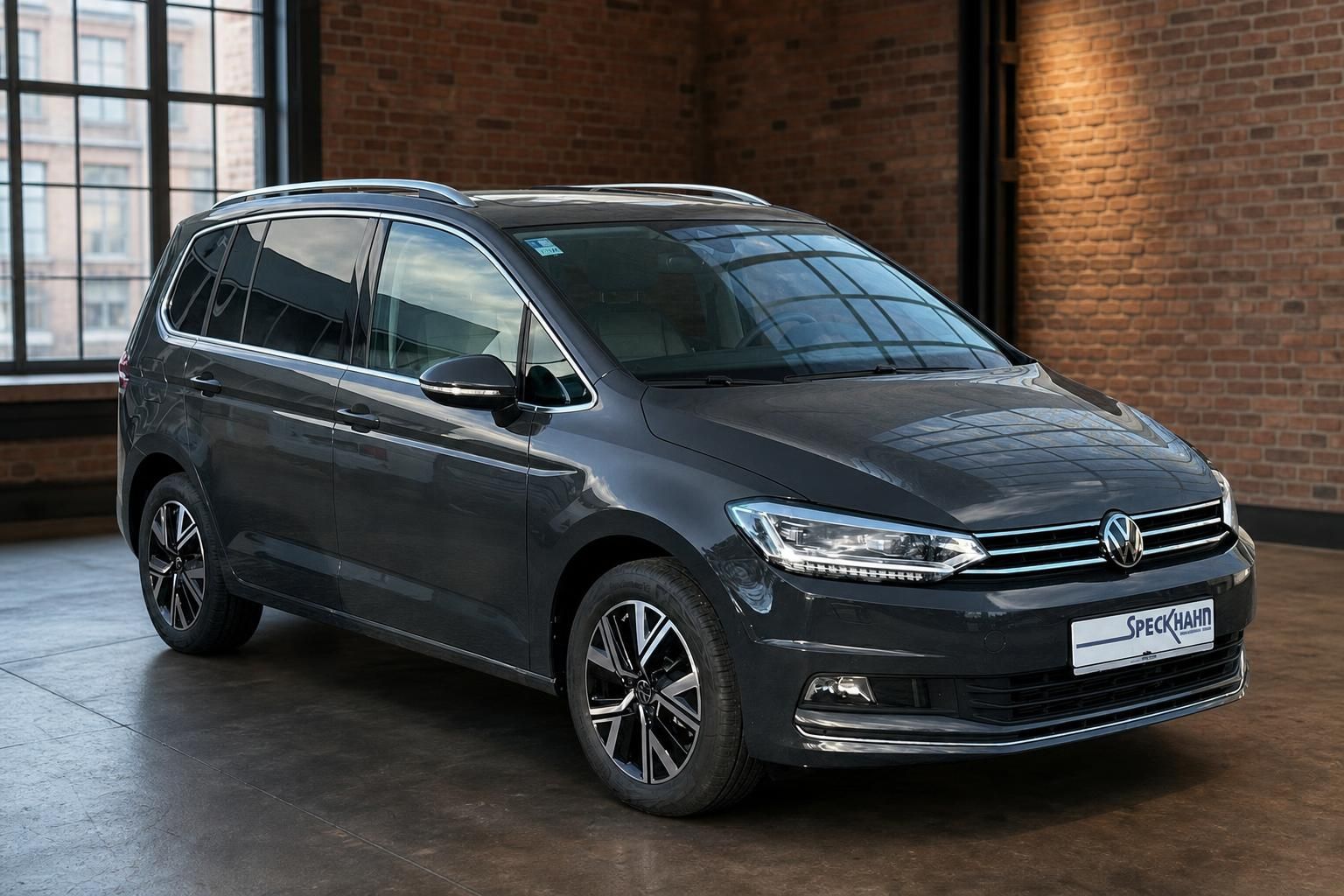 VW Touran grau metallic Frontansicht seitlich in Loft-Ambiente