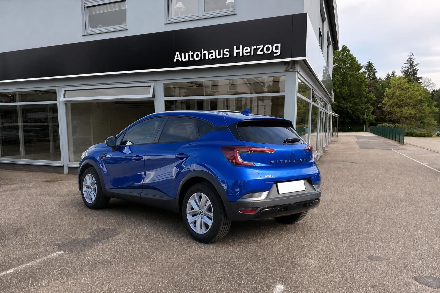 Blauer Mitsubishi SUV Außenansicht von hinten vor Autohaus Herzog