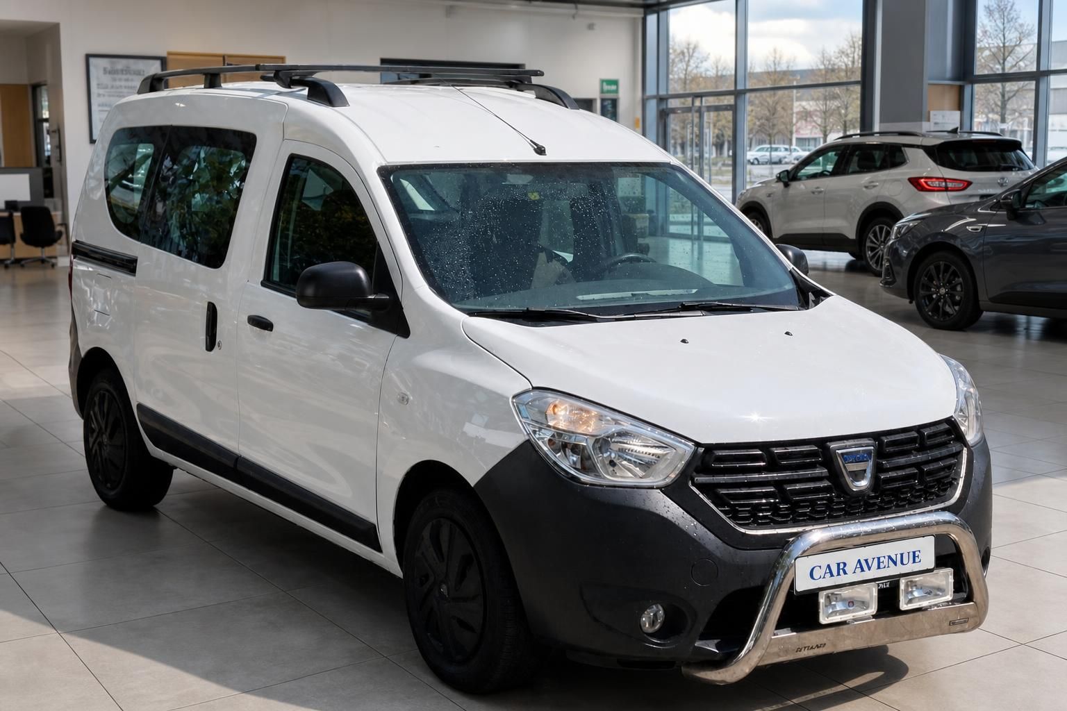 Dacia Dokker weiss Frontansicht schraeg links im Autohaus mit Frontbuegel und Dachtraeger