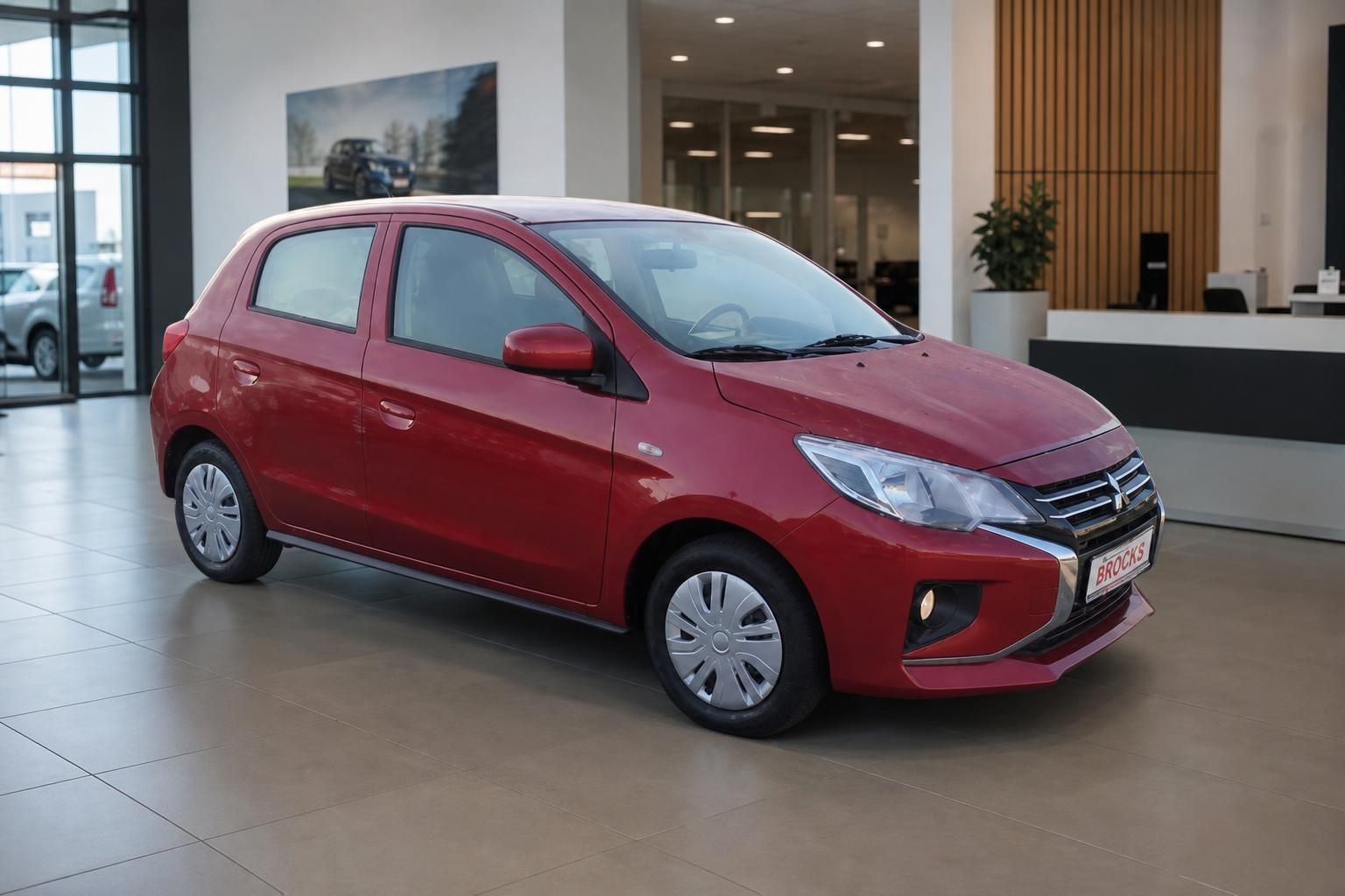 Roter Mitsubishi Space Star Kompaktwagen Schrägansicht im Autohaus mit Dealer-Kennzeichen