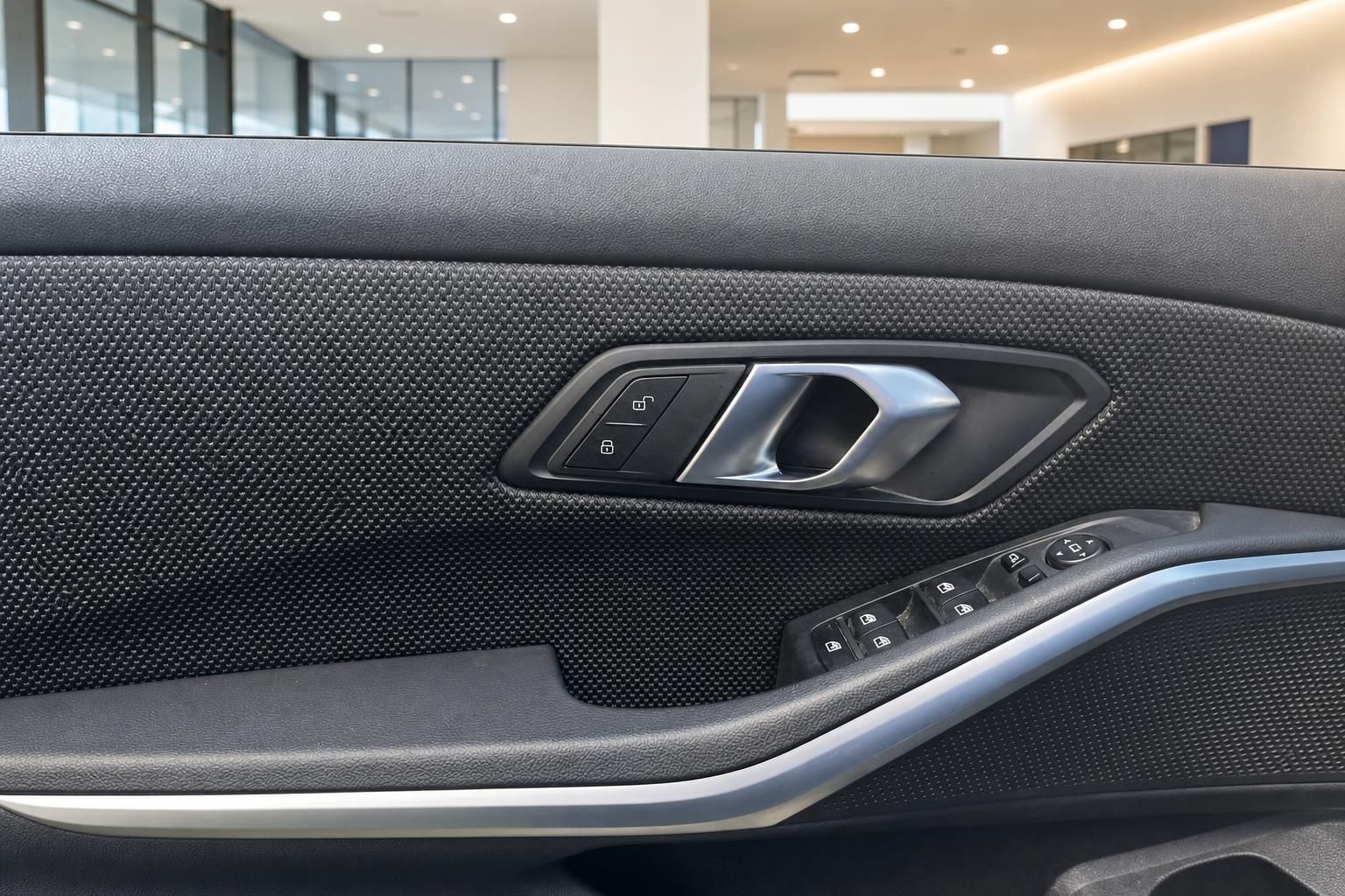 Türverkleidung mit Griff und Fensterheber-Bedienelementen im BMW Innenraum