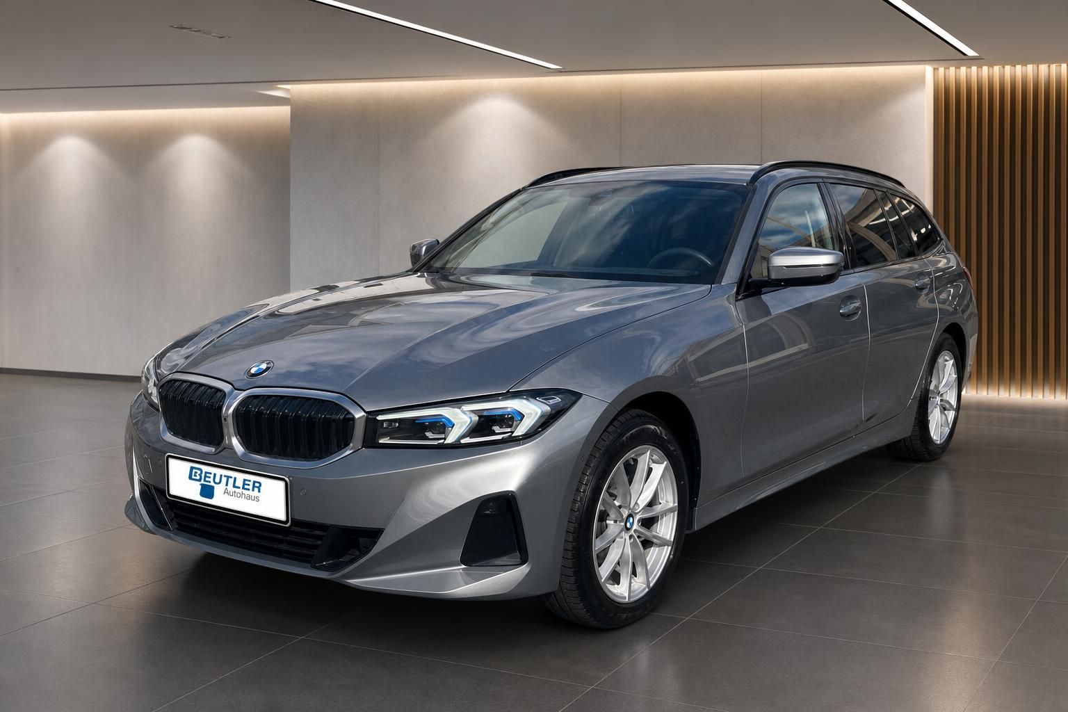 BMW 3er Touring in Grau, Frontansicht schraeg im Showroom