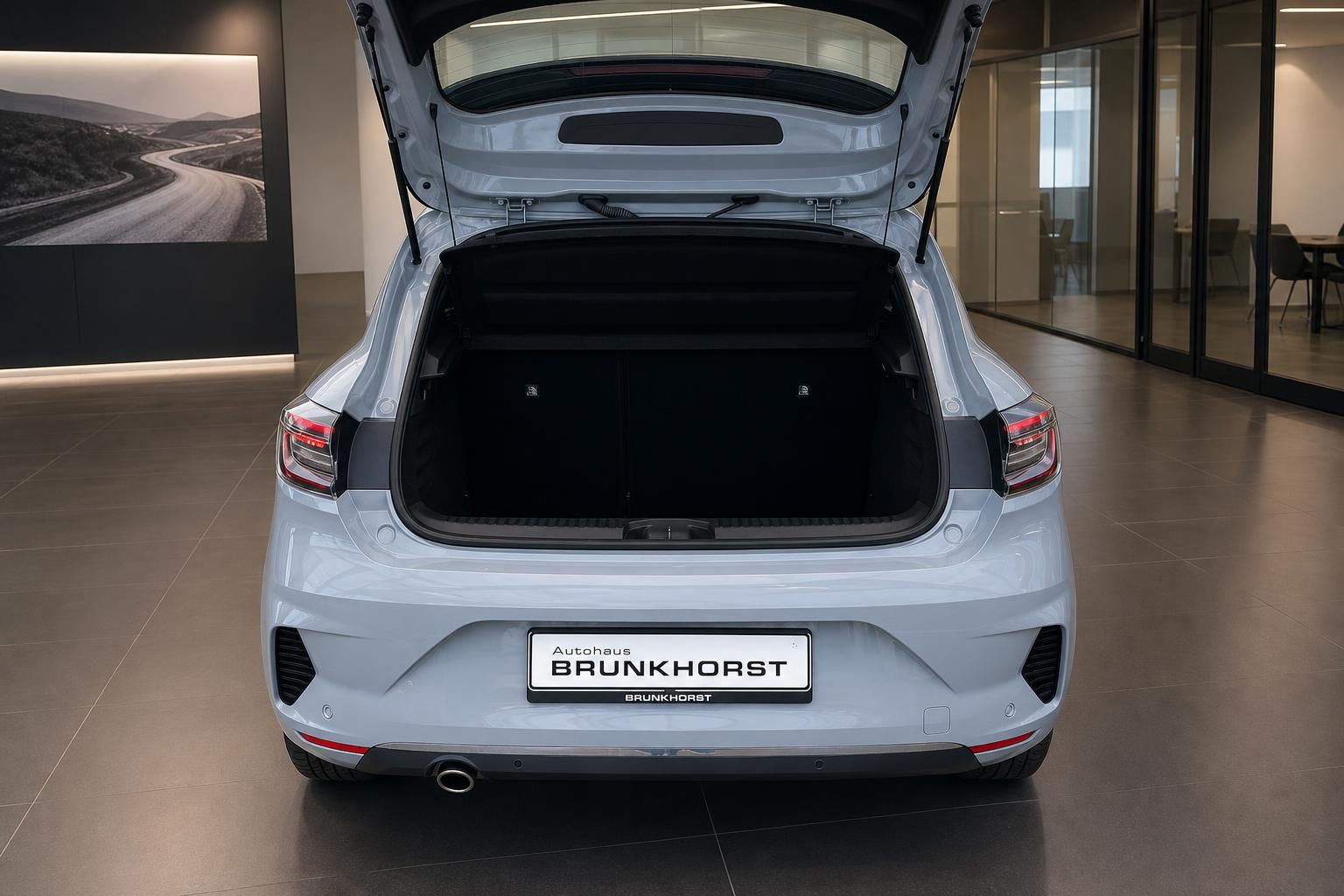 Renault mit geöffnetem Kofferraum in weiß, Heckansicht im Autohaus