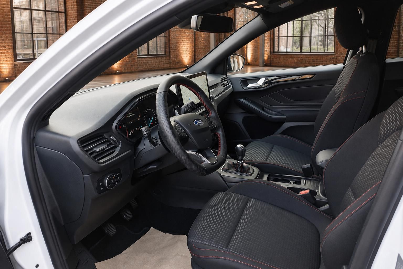 Ford Focus Innenraum Fahrerseite mit Lenkrad, Touchscreen, Schaltgetriebe und schwarzen Sportsitzen