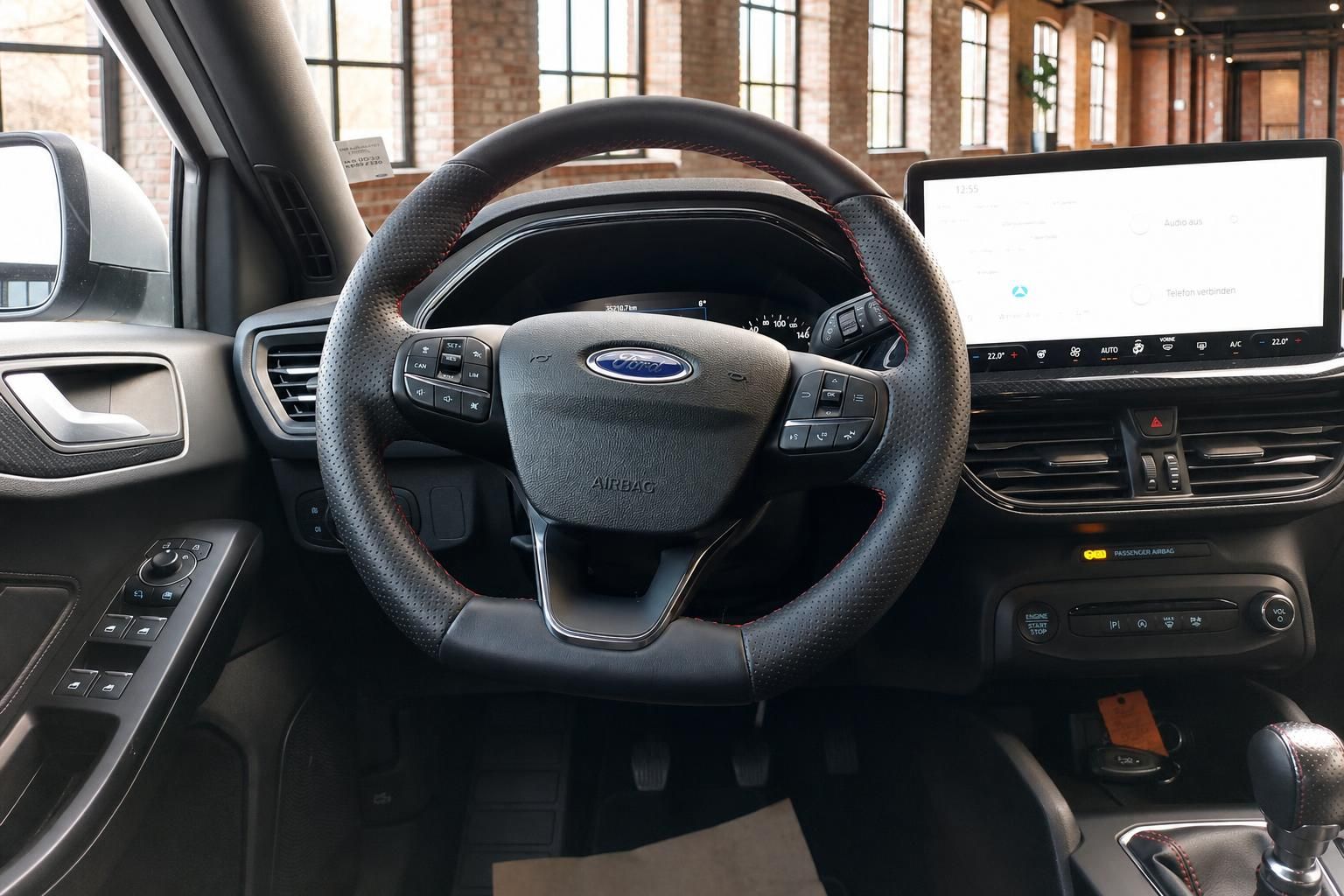 Ford Focus Lenkrad mit Multifunktionstasten und großem Infotainment-Display im Hintergrund