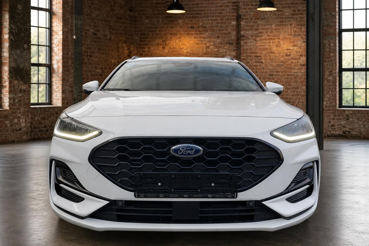 Ford Focus Turnier weiss Frontansicht mit LED-Scheinwerfern und schwarzem Wabengrill in Industriehalle