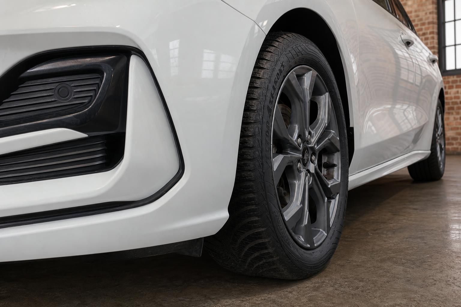 Ford Focus Turnier weiss Detailaufnahme Vorderrad mit Leichtmetallfelge und Stossfaenger