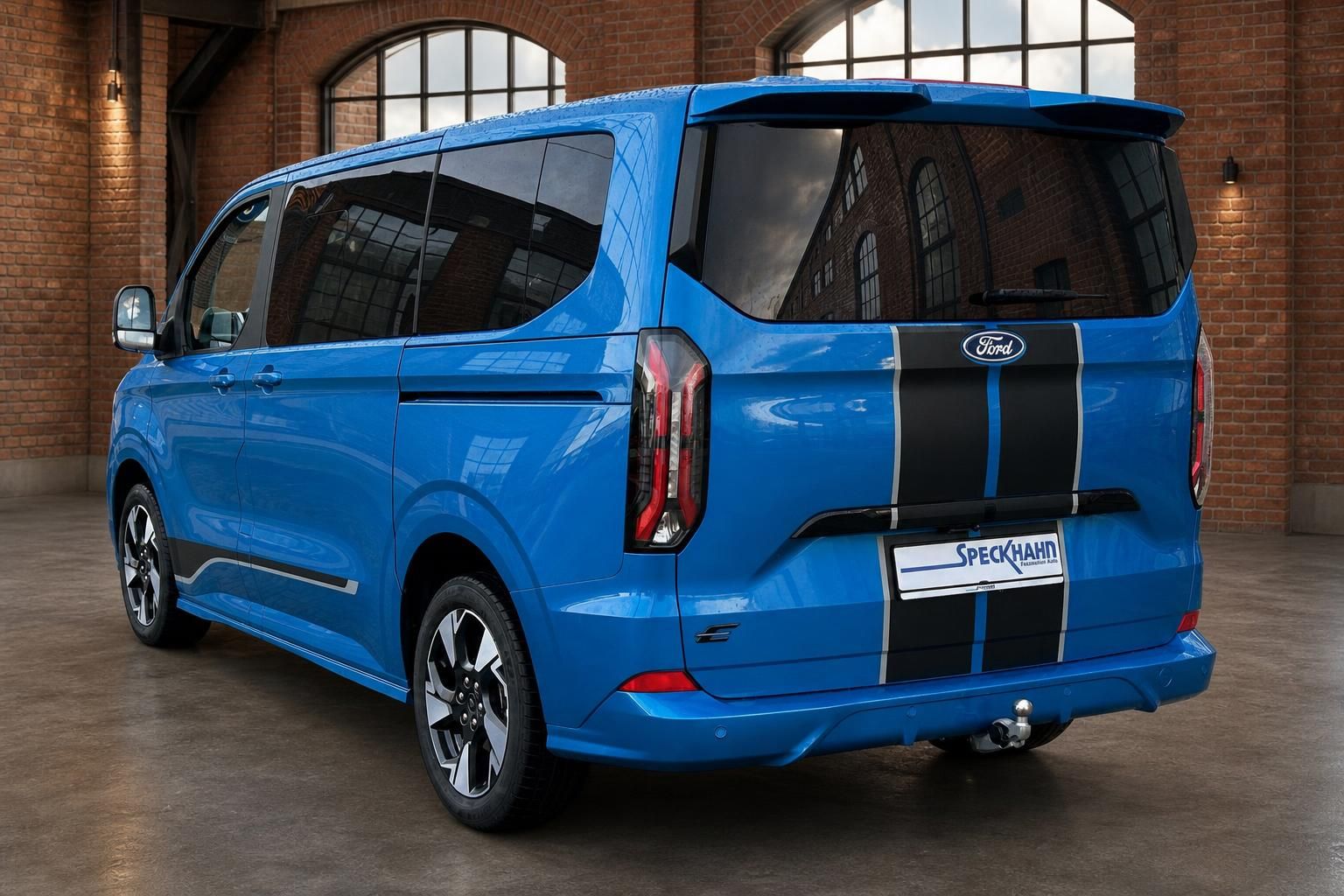 Ford Tourneo Custom blau, Heck-Seitenansicht in Backsteinhalle