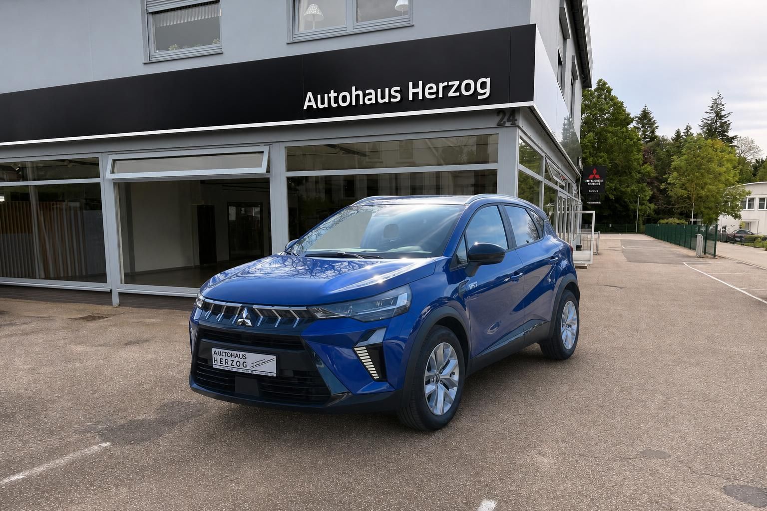 Blauer Mitsubishi SUV Frontansicht vor Autohaus Herzog Showroom