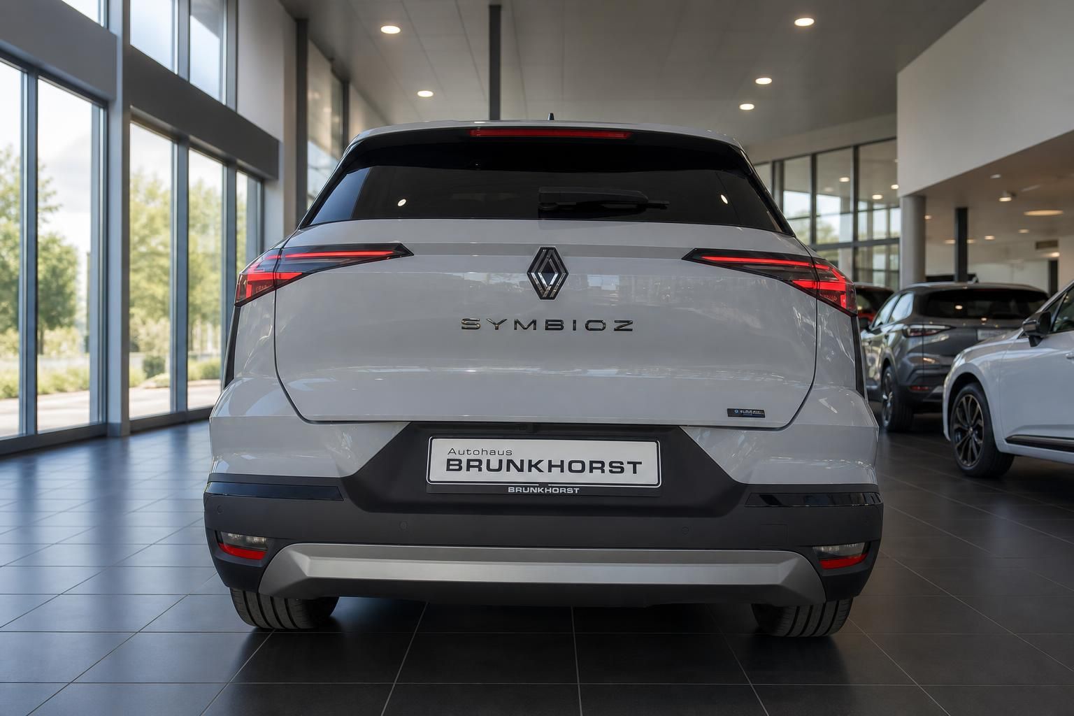 Renault Symbioz Heckansicht in silber mit LED-Rückleuchten im Autohaus-Showroom