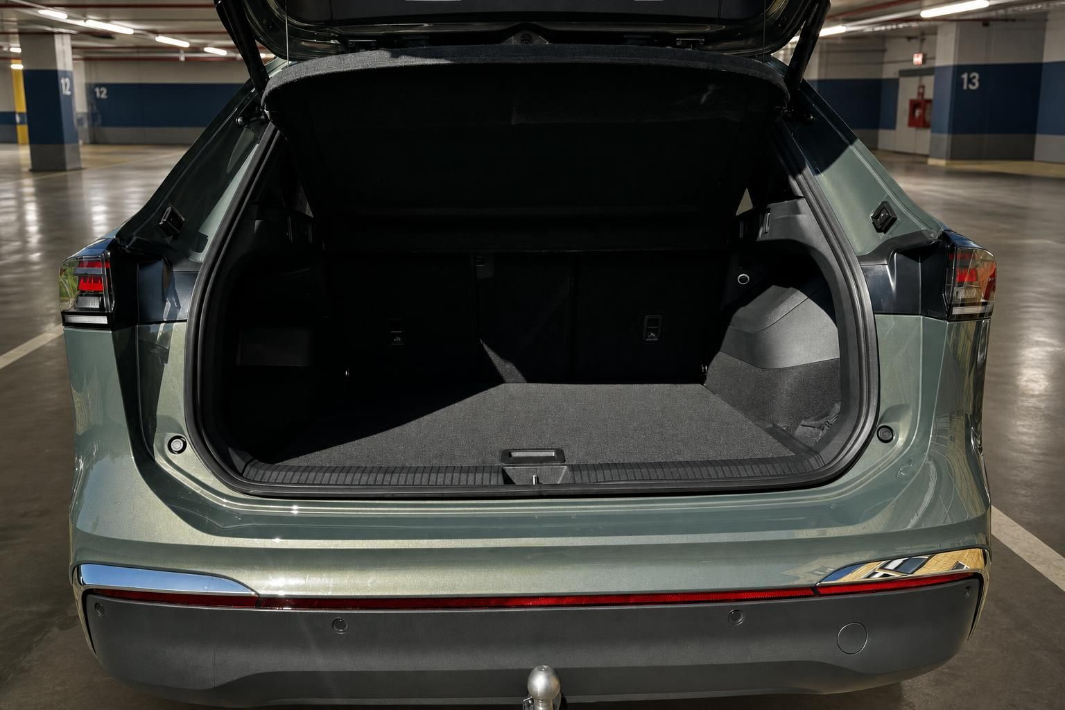 VW Tiguan Kofferraum geöffnet in grün metallic mit Anhängerkupplung im Parkhaus