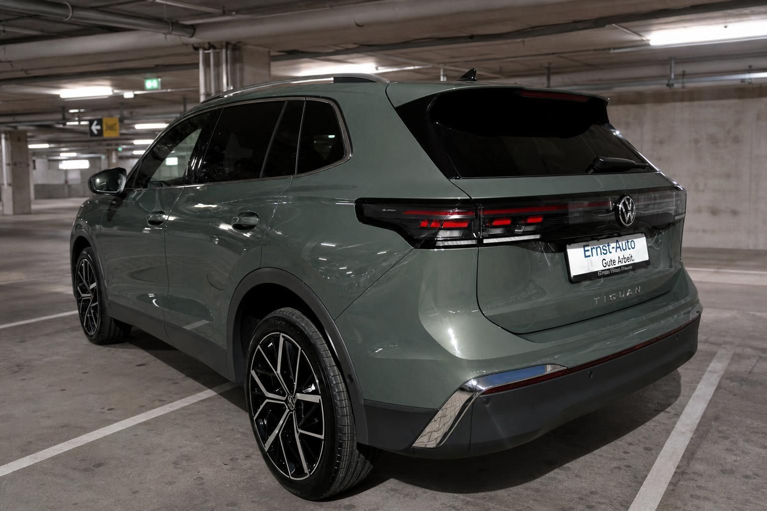 VW Tiguan grün Heckansicht schräg rechts im Parkhaus – LED-Rückleuchten und Alufelgen