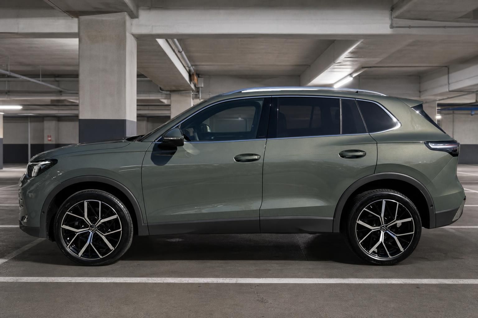 SUV grün Seitenansicht links im Parkhaus – große Alufelgen und modernes Design