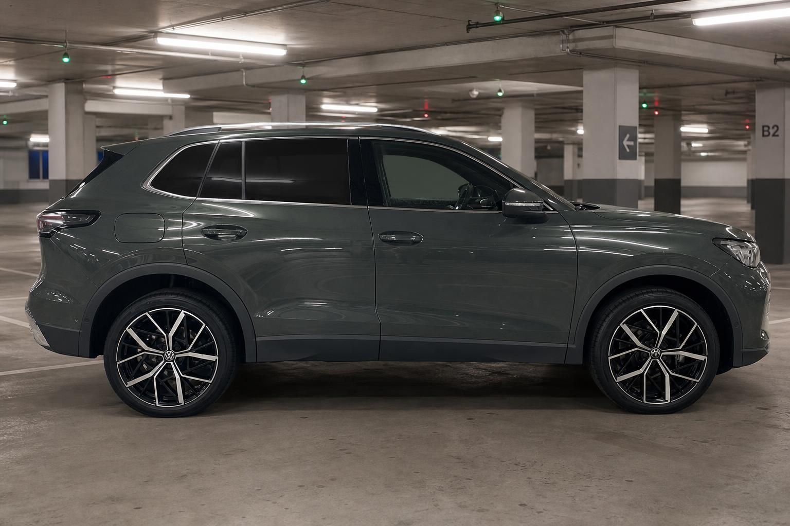 VW Tiguan grün Seitenansicht in Parkhaus – SUV mit schwarzen Leichtmetallfelgen