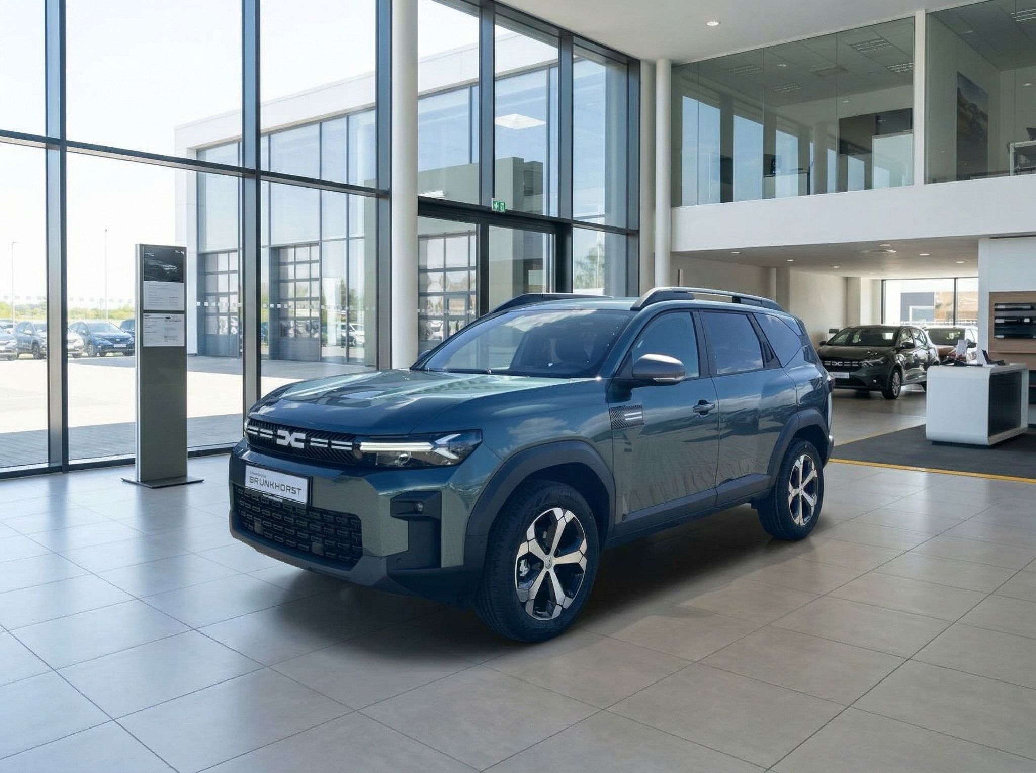 Dacia Bigster SUV in grün im Autohaus Showroom - Seitenansicht