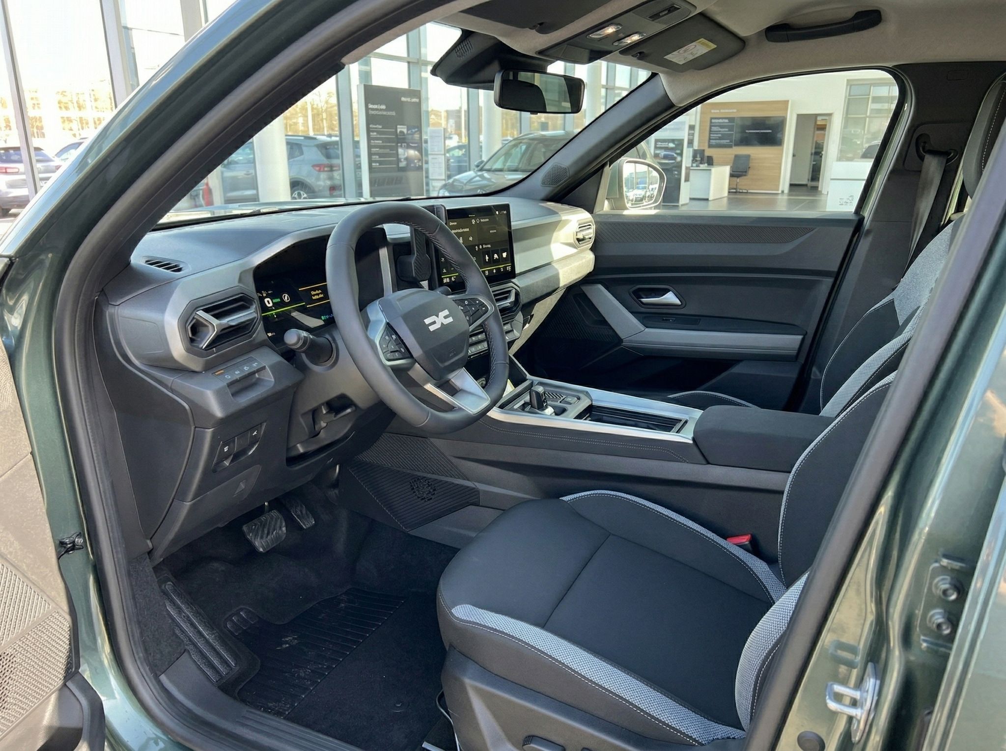 Moderner Fahrzeuginnenraum mit Lenkrad, Touchscreen und Sportsitzen