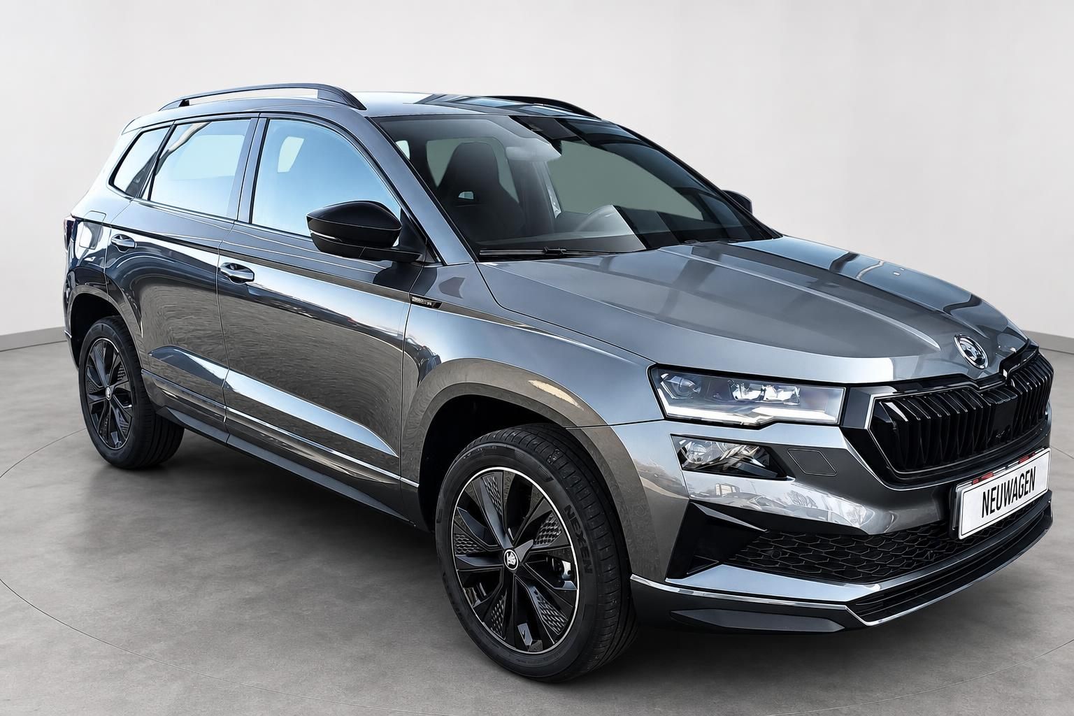 Skoda Karoq Neuwagen in Grau, Frontansicht mit markanten Scheinwerfern