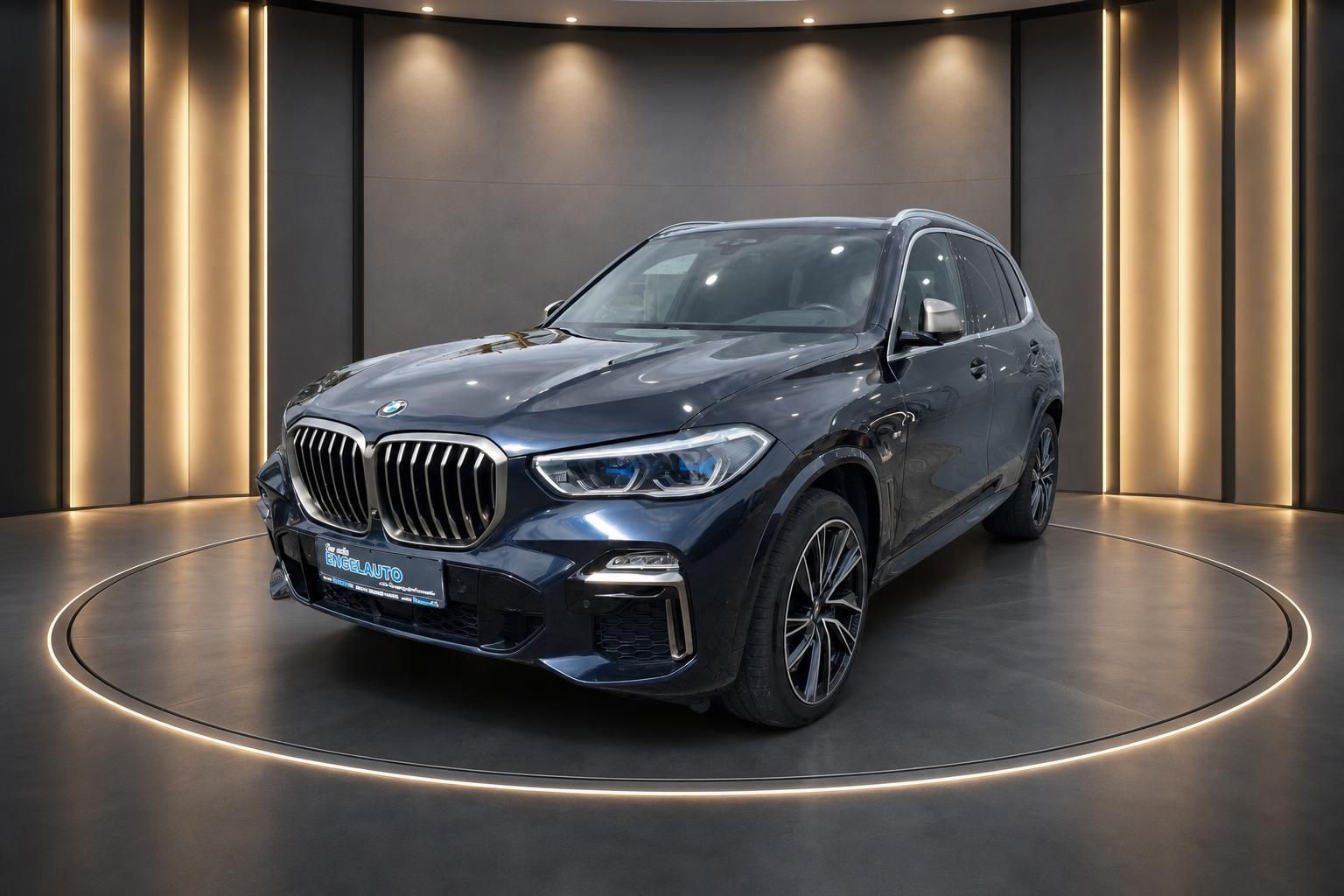 BMW X5 SUV dunkelblau metallic Frontansicht schräg mit LED-Scheinwerfern in elegantem Showroom