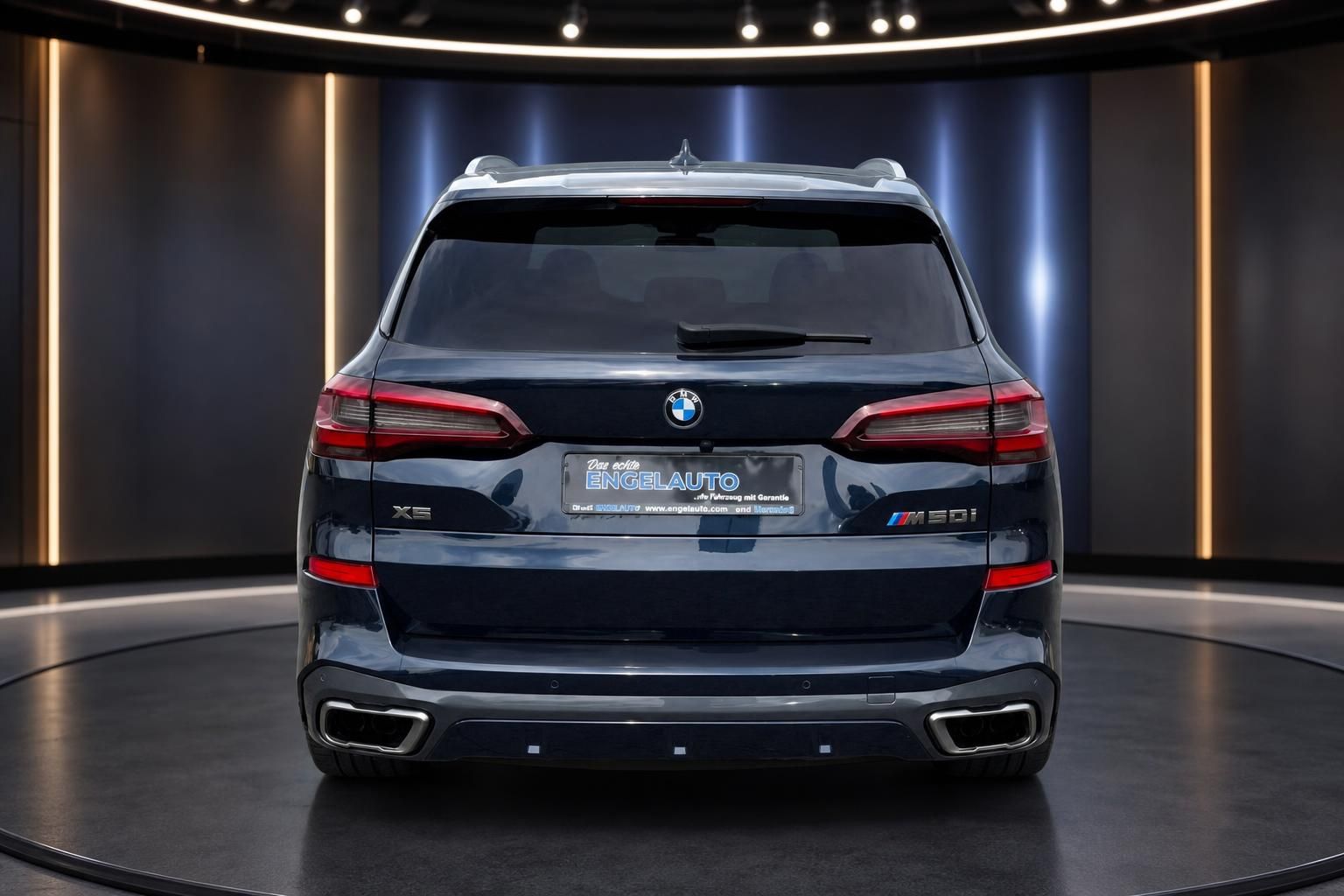BMW X5 SUV dunkelblau metallic Heckansicht mit LED-Rückleuchten und Doppelendrohr in Showroom