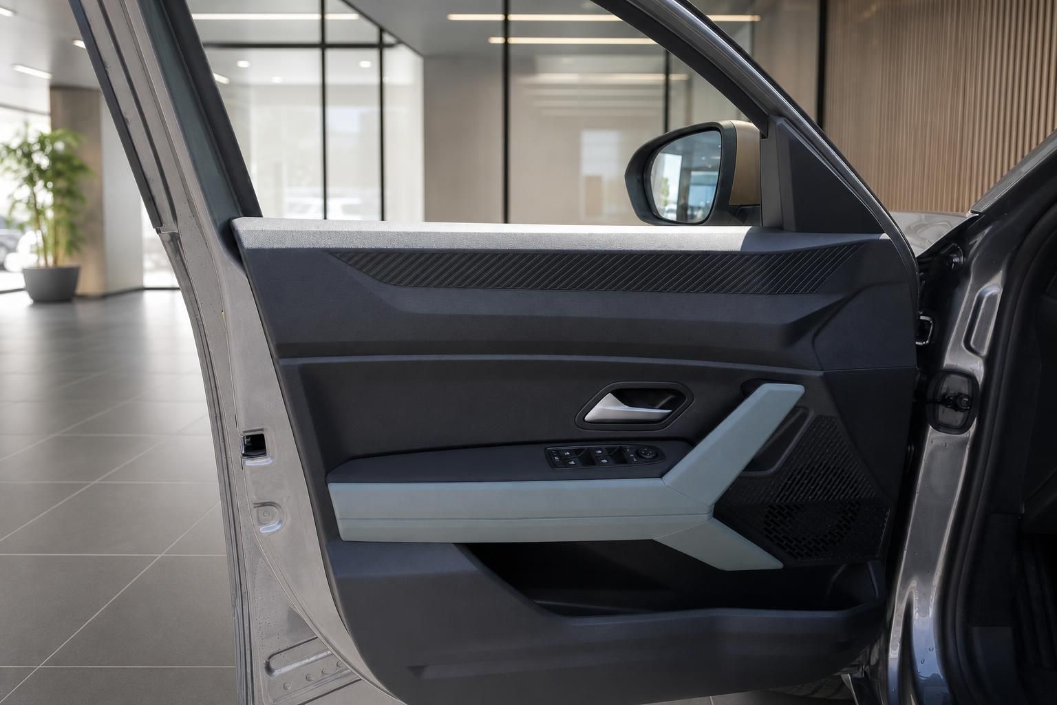 Offene Fahrertür mit Blick auf Türverkleidung und Außenspiegel des Dacia