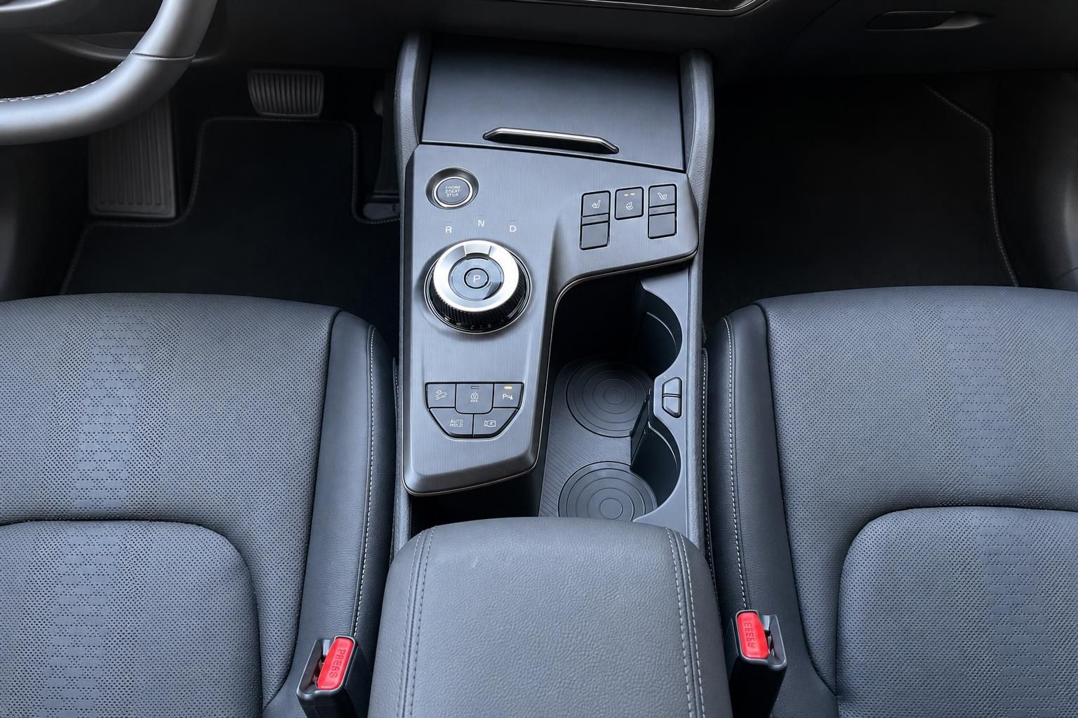 Mittelkonsole mit Drehregler-Schalthebel und Getraenkehaltern im Fahrzeuginterieur