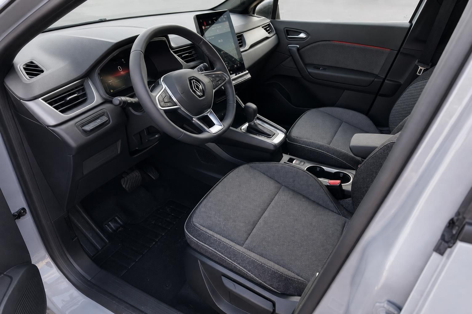 Renault Captur Innenraum - schwarze Sitze, Lenkrad und modernes Infotainment-Display im Cockpit