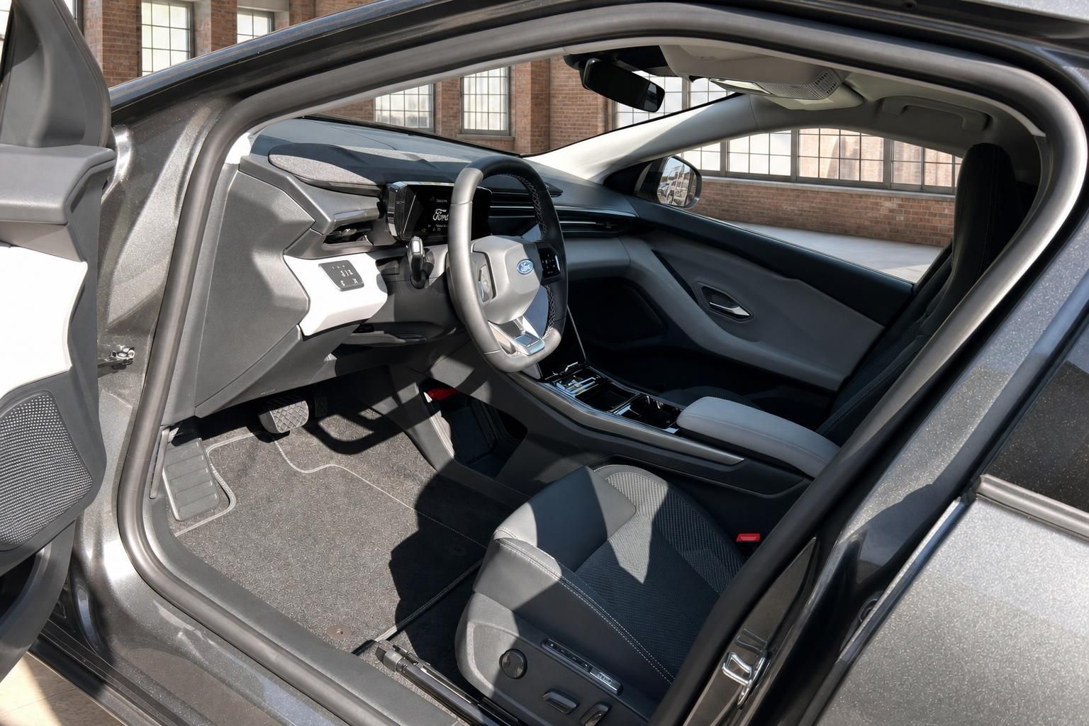 Ford Explorer Elektro Innenraum mit Cockpit, Lenkrad und hellen Sitzen durch offene Fahrertür
