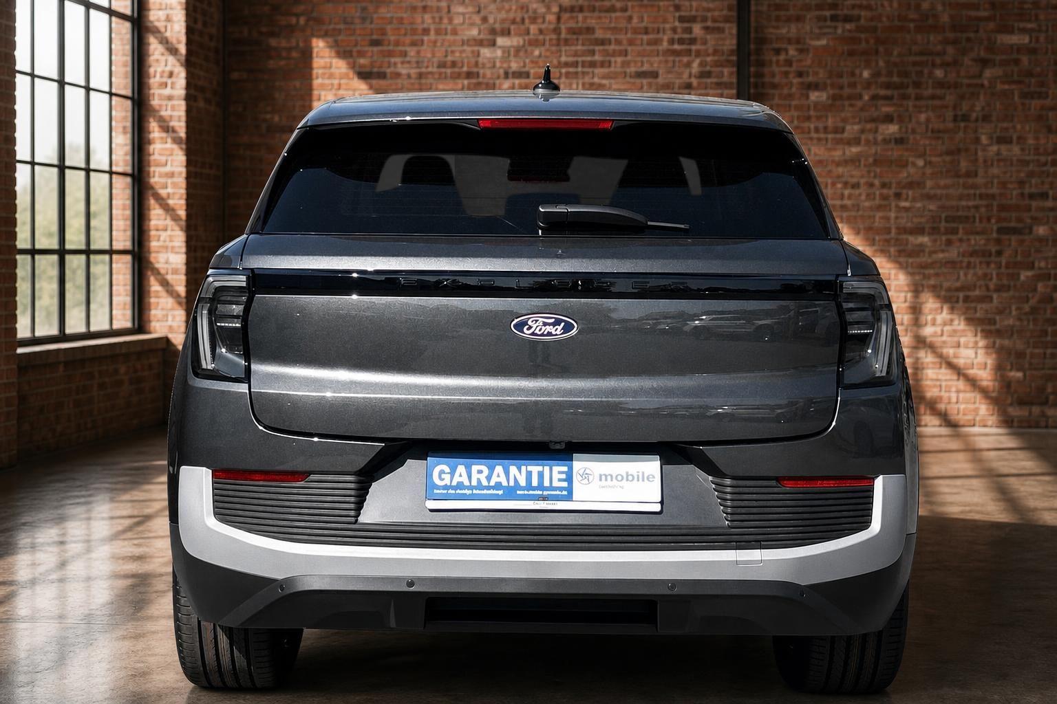 Ford Explorer Electric SUV grau direkte Heckansicht mit Ford Logo und Garantie mobile Kennzeichen