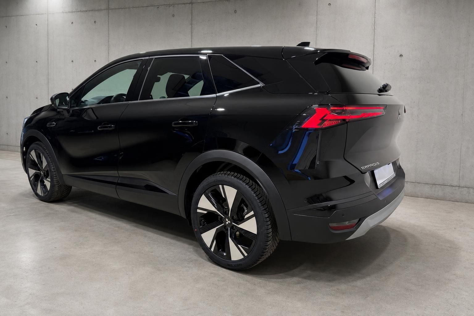 Mitsubishi Grandis schwarz Seiten-Heckansicht mit Alufelgen im Studio