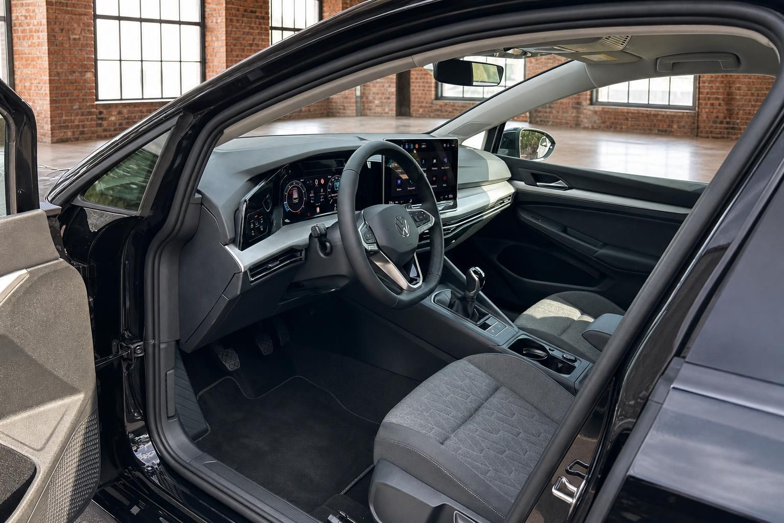 VW Golf Innenraum mit Cockpit, Lenkrad und digitalem Tacho durch offene Tür