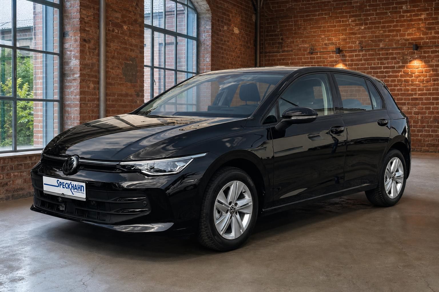 VW Golf schwarz Frontperspektive vor Backsteinwand im Autohaus
