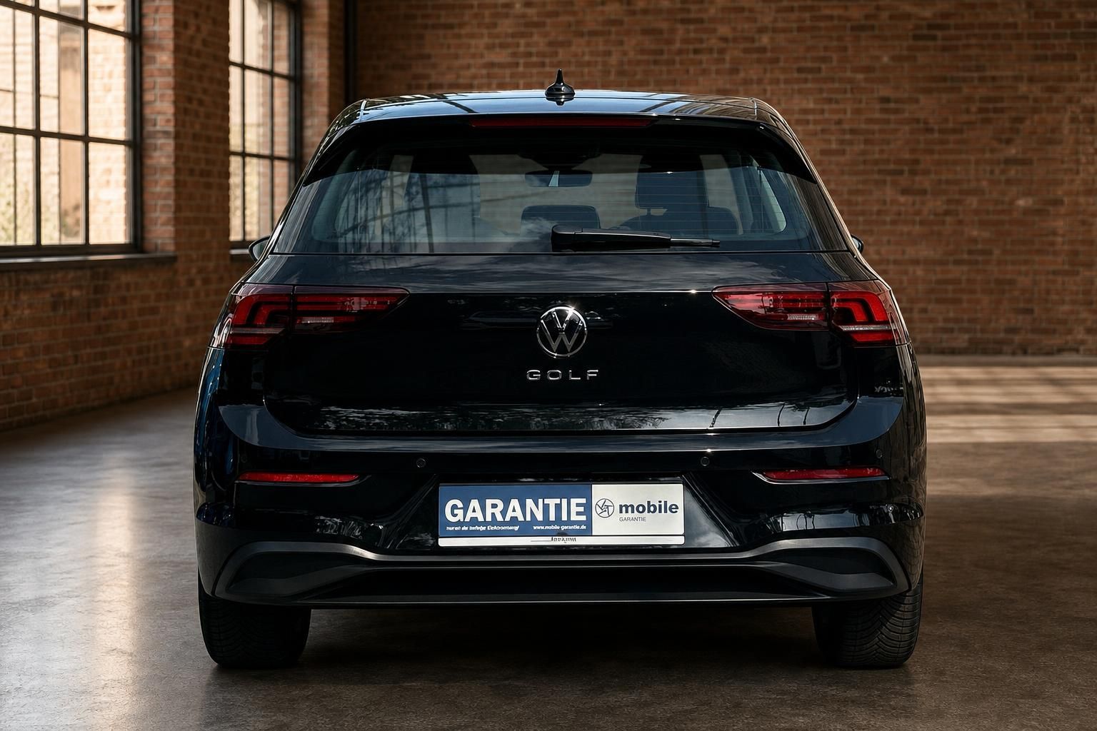 VW Golf schwarz Heckansicht in Loft-Halle mit Backsteinwand